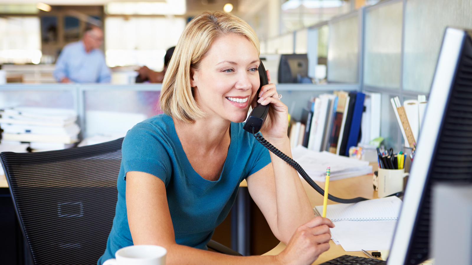 A businesswoman using telecom solutions while talking with her client on the phone